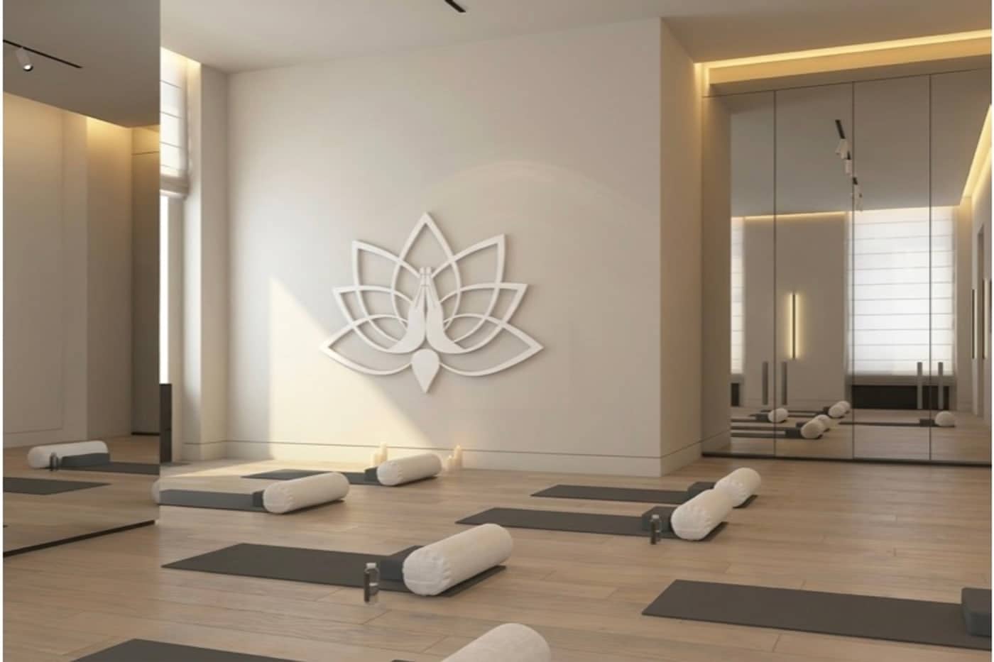 A bright hall with mats and bolsters set out below the lotus mark in relief on the wall