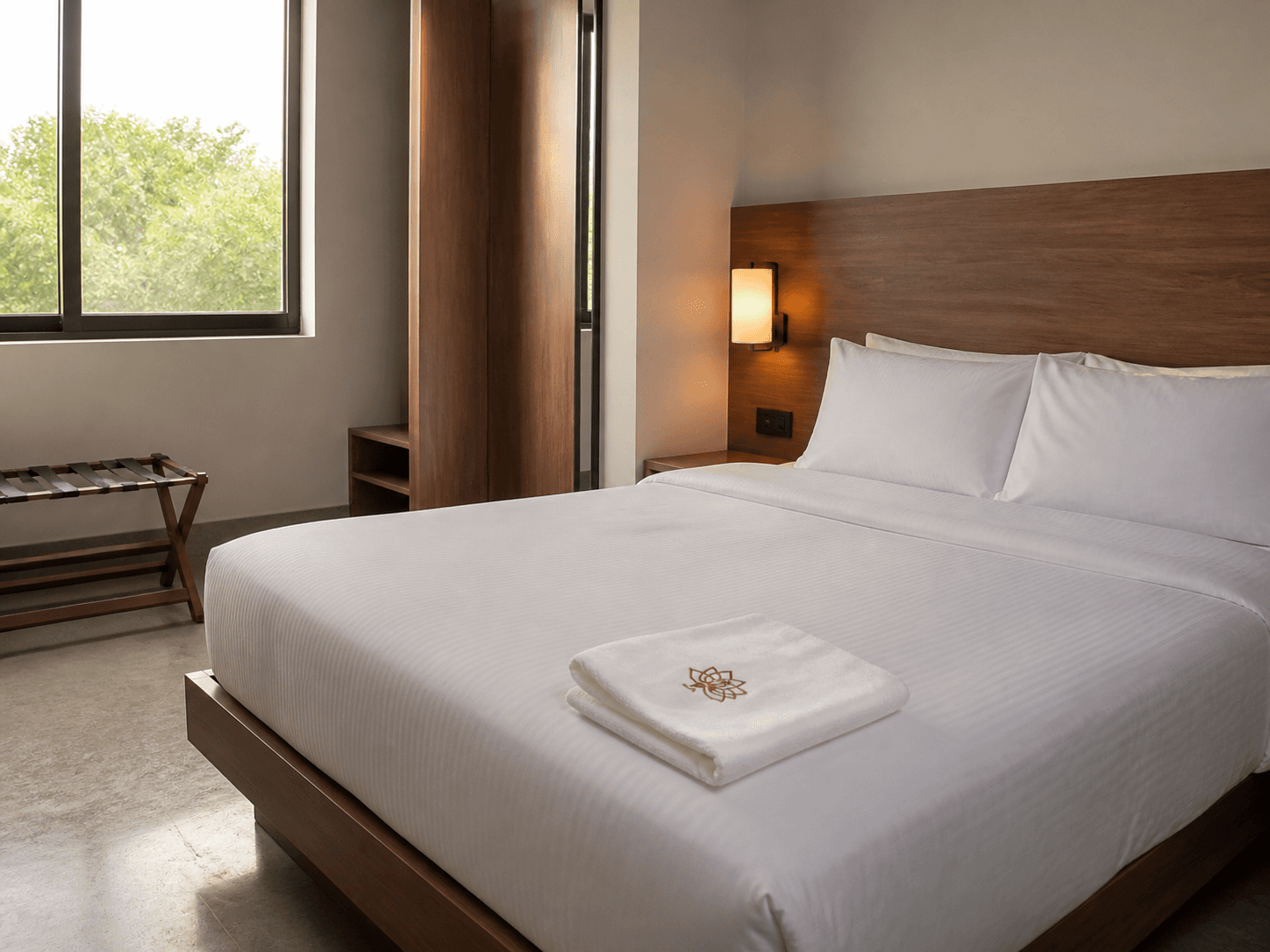 A bright Bhaktashray guest room prepared with fresh white linen